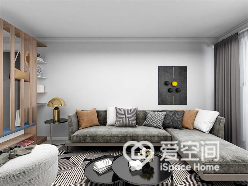 客厅在设计上以白色为背景，灰色沙发形成了一个充满氛围感的空间，暖色抱枕打破了这份单调感。