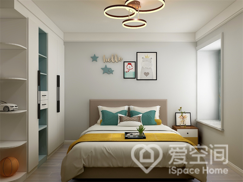 为了使儿童房不显单调，设计师在背景墙上运用了卡通装饰画，并用灯饰装饰照亮整个空间。