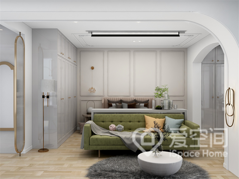 客厅与卧室相连，粉色背景墙中采用了石膏线勾勒，让空间看起来宽敞明亮之余，更添一份精致感，绿色沙发宁静雅致，很有现代腔调，置身于此能安静地享受家的温暖与诗意。