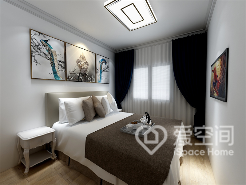 白色空间中，中式挂画释放出温馨宁静的感觉，床品配色富有层次感，干净的颜色令空间显得更大。