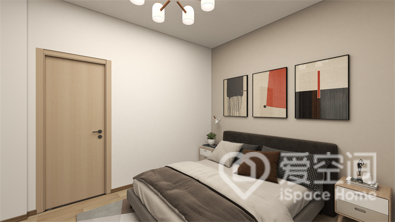次卧背景墙大面积留白，床体造型简洁，墙体间加入艺术画点缀，整体效果显得简洁而大气。