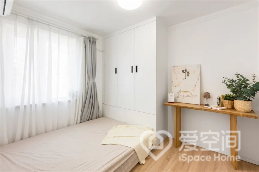 次卧选用了低洗位的榻榻米，基本用不上的收纳空间取消掉，直接用地天立地的衣柜，其实已经拥有了足够的收纳位置，因此可以获得更高的舒适感和更优的视觉美感。