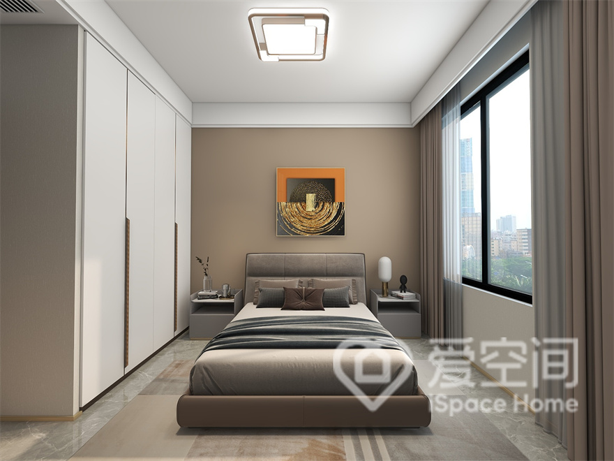 次卧的米色背景中饰以精巧雅致的挂画，入墙衣柜勾勒出空间层次感，呈现出简单舒适、温馨实用的氛围。